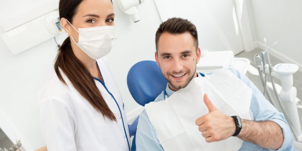 Young,Doctor,Dentist,And,Patient,Showing,Thumb,Up.,Healthy,Teeth